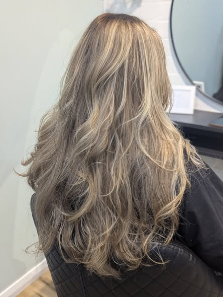 A dimensional blonde balayage styled into soft waves at The Hair Republic