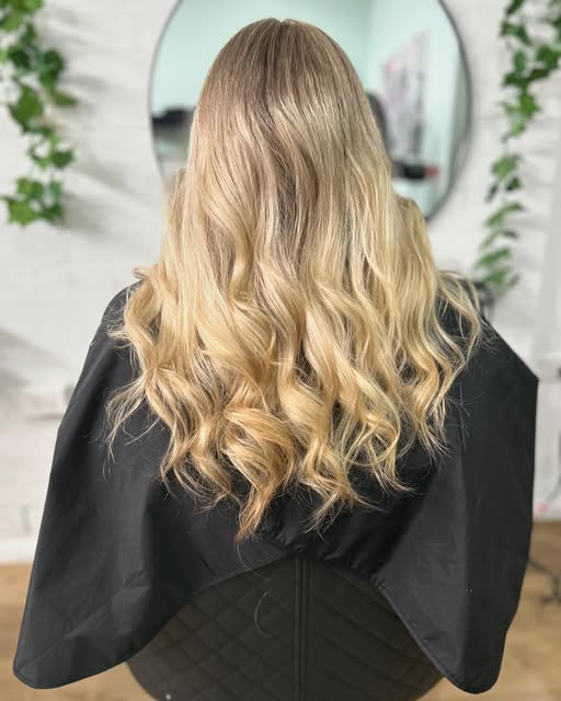 Long golden blonde hair blow-dried into waves